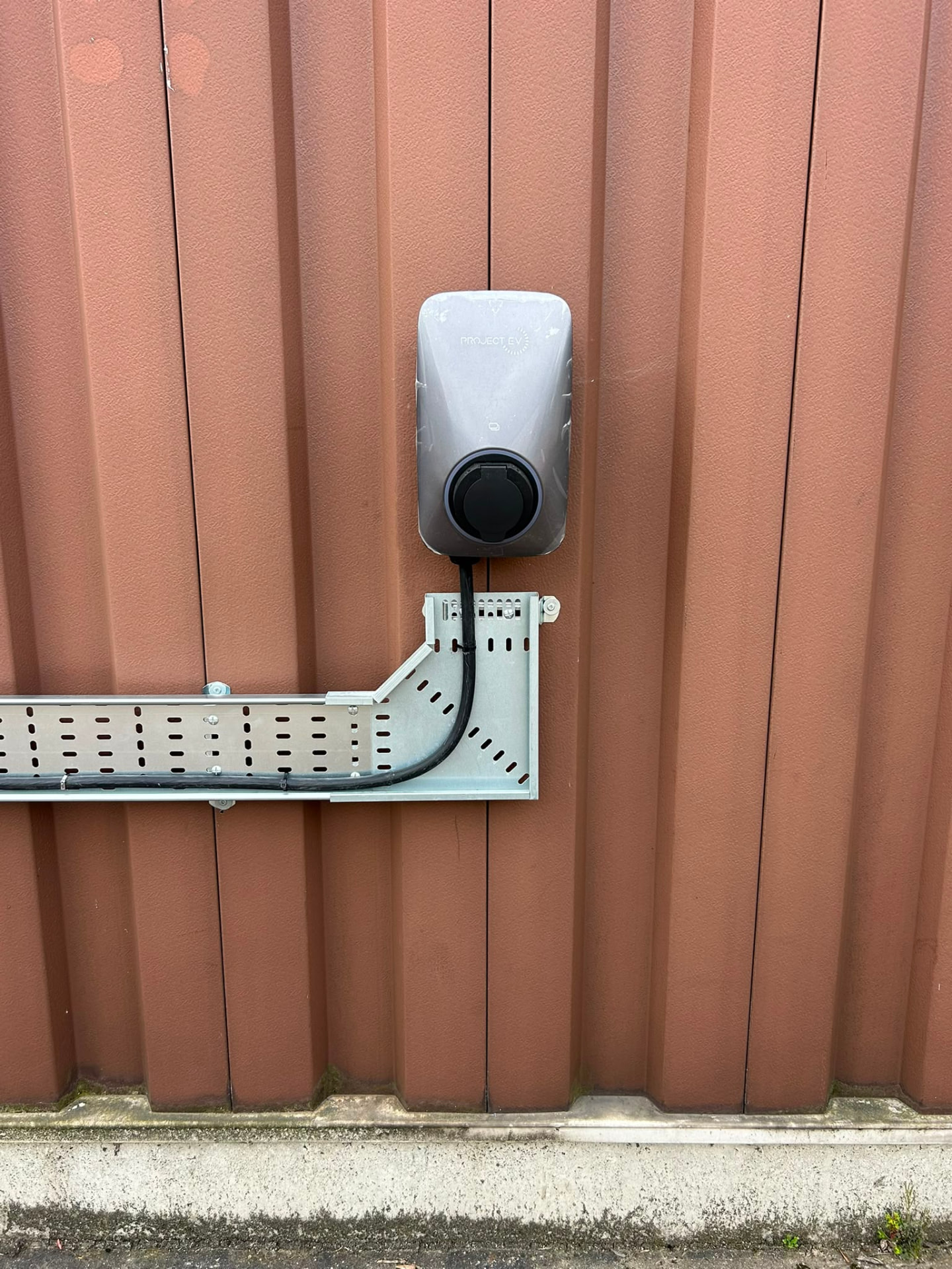 Commercial EV charger with containment and cable tray feeding the unit