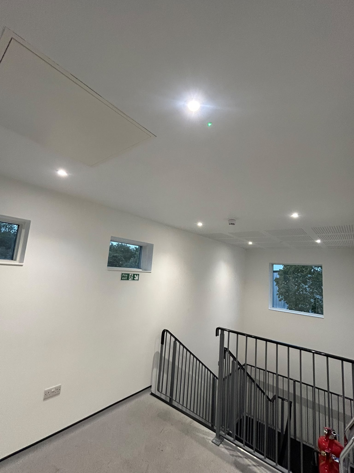 Commercial stairwell and landing illuminated by recessed lighting